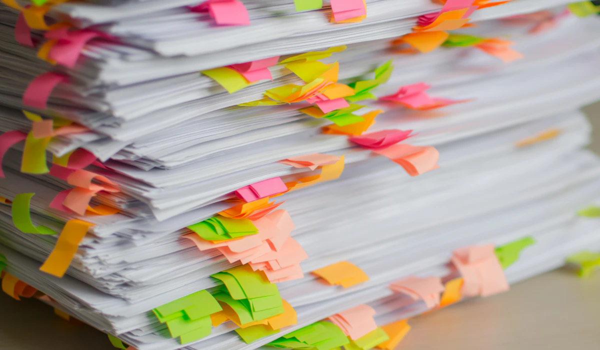 A stack of documents flagged with colored sticky tabs