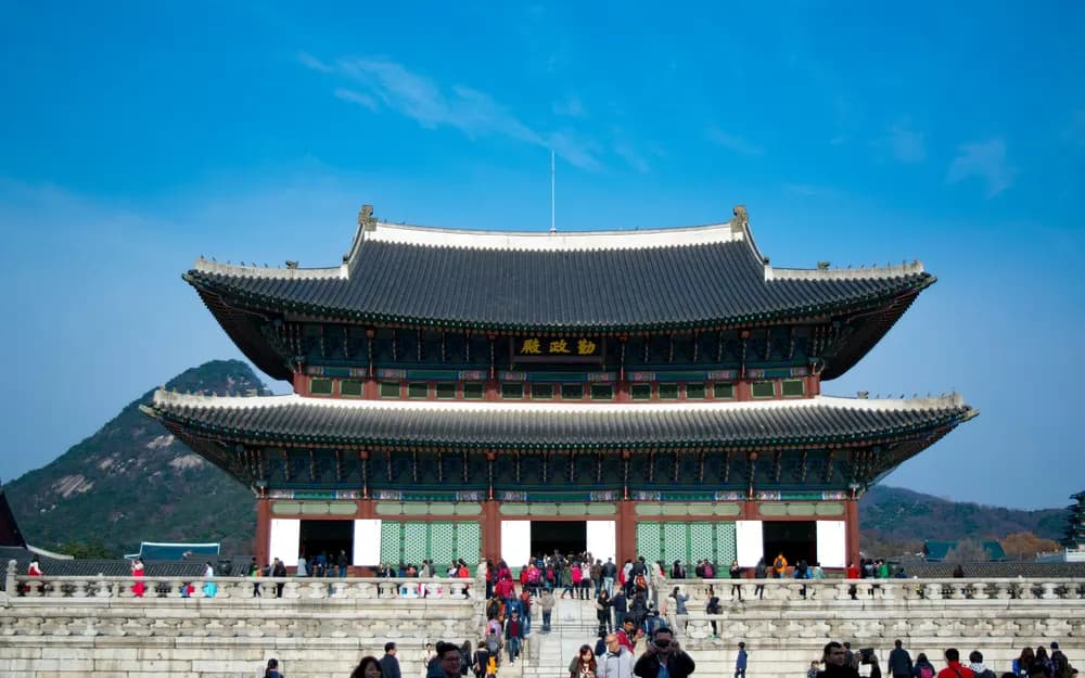 Gyeongbokgung Palace in Seoul with mountains rising behind its roofs