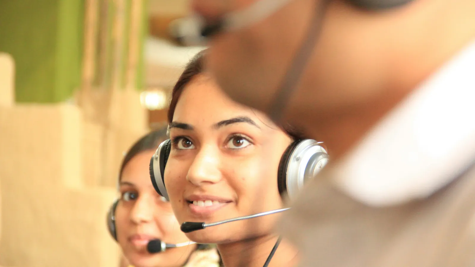 Simultaneous interpreters wearing headsets and microphones while working as a team